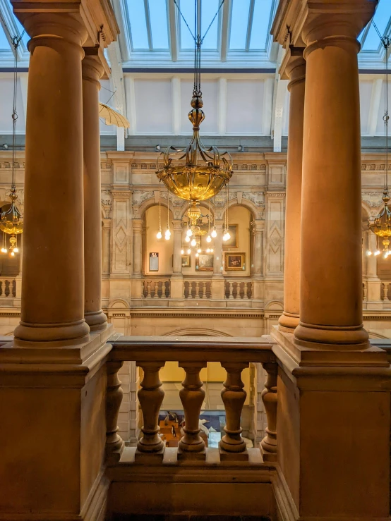 the inside of a building with columns and chandeliers, inspired by Frederick Goodall, pexels contest winner, art nouveau, in legnica city hall, profile image, sitting on a grand staircase, high view