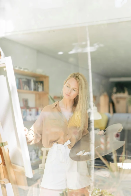 a woman standing in front of a painting easel, a photorealistic painting, pexels contest winner, looking in the window, white hue, reflecting, architect studio