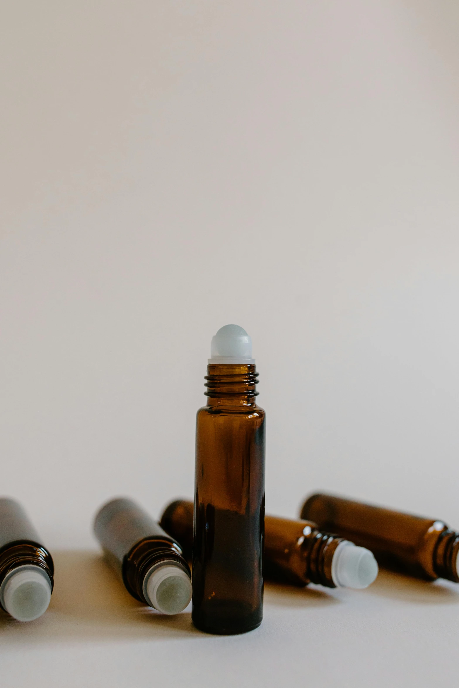 a group of bottles sitting on top of a table, product image, amber, on a pale background, 33mm photo