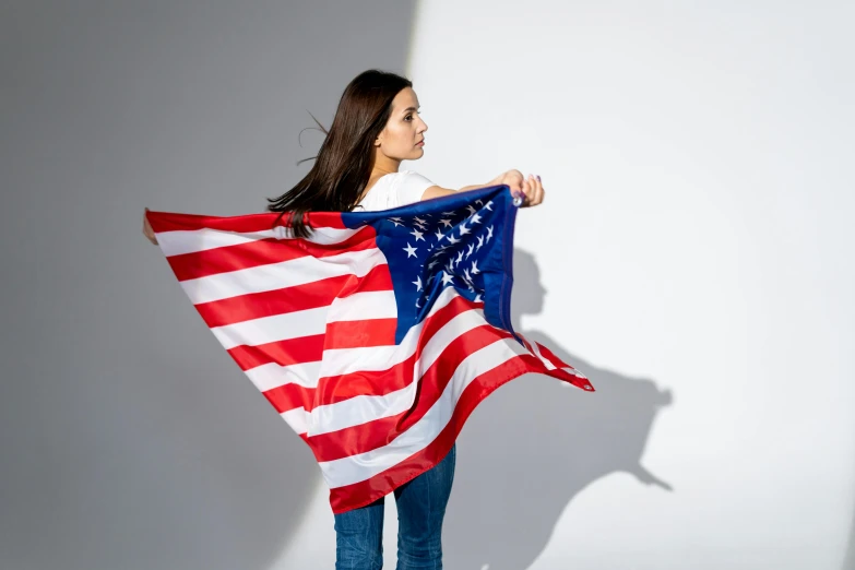 a woman holding an american flag in her hands, a portrait, shutterstock contest winner, alexandria ocasio-cortez, studio shoot, flying shot, anastasia ovchinnikova