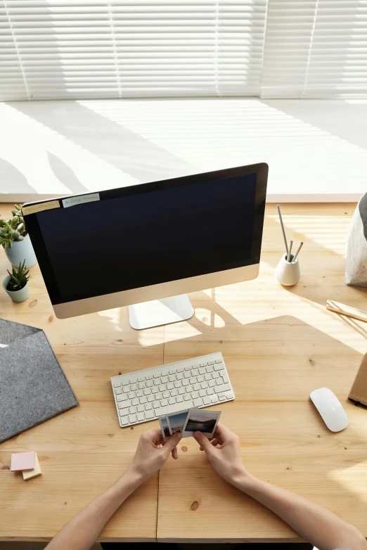 a person sitting at a desk using a cell phone, a computer rendering, trending on pexels, sustainable materials, old computer monitor, modern minimalist f 2 0, centered shot