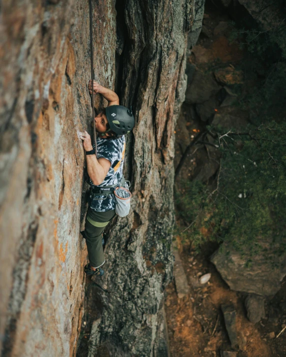 a man climbing up the side of a mountain, by Jessie Algie, pexels contest winner, manuka, high angle vertical, textured, female ascending