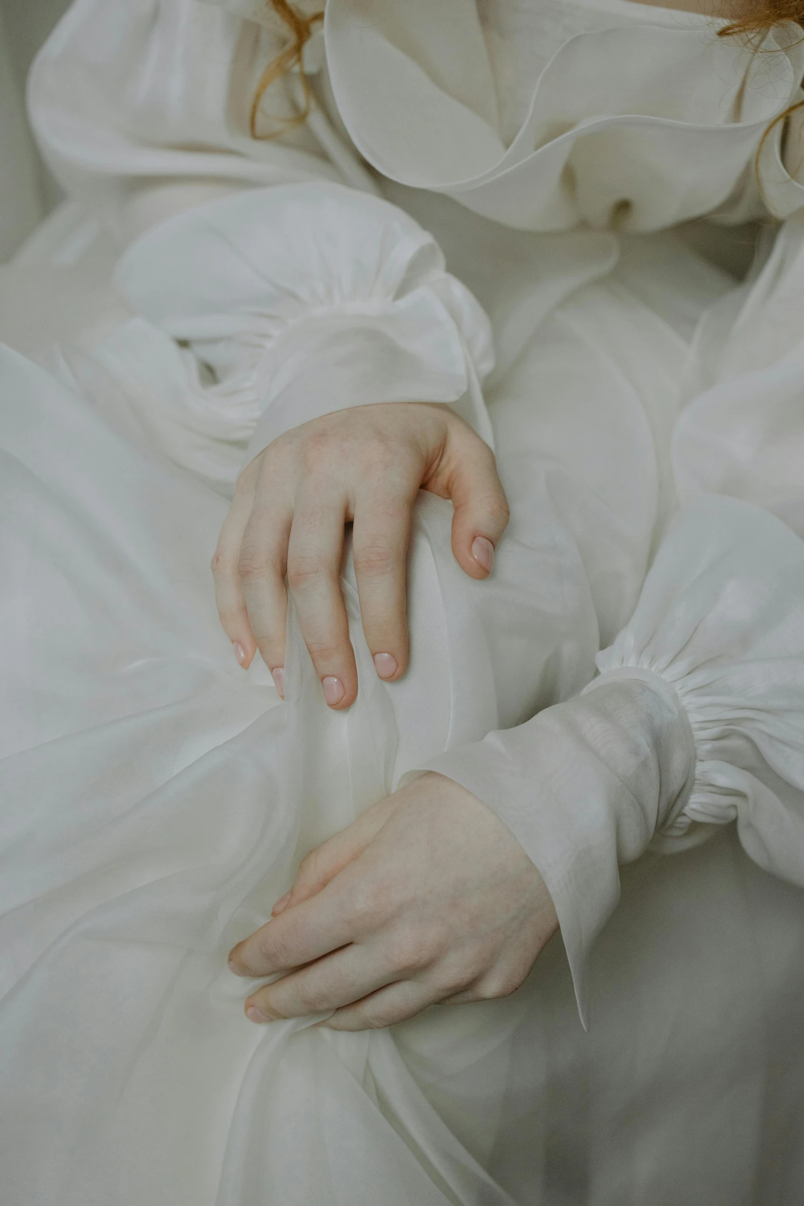 a close up of a woman in a white dress, an album cover, inspired by Elsa Bleda, unsplash, romanticism, laying down with wrists together, (12x) extremely pale white skin, silk robes, holding hands