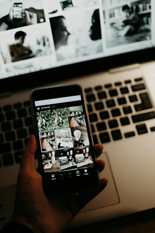 a person holding a cell phone in front of a laptop, a black and white photo, trending on pexels, happening, instagram highlights, old photo scattered, brown, multi-dimensional