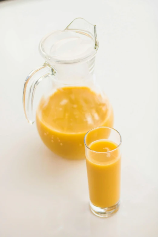 a pitcher of orange juice next to a glass of orange juice, reddit, vanilla smoothie explosion, thumbnail, close body shot, 1 2 9 7