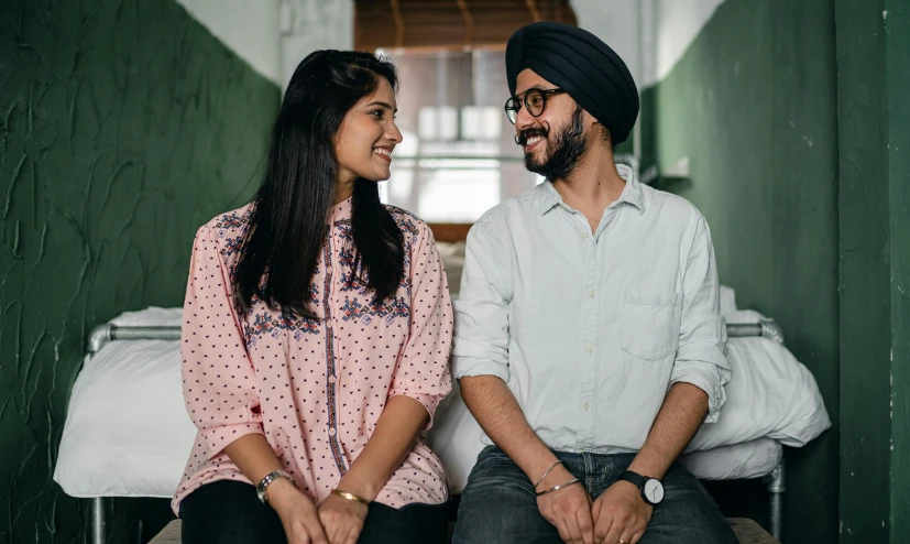 a man and a woman sitting on a bed, a portrait, inspired by Manjit Bawa, pexels contest winner, hurufiyya, slight nerdy smile, looking to the side, nerds, thumbnail