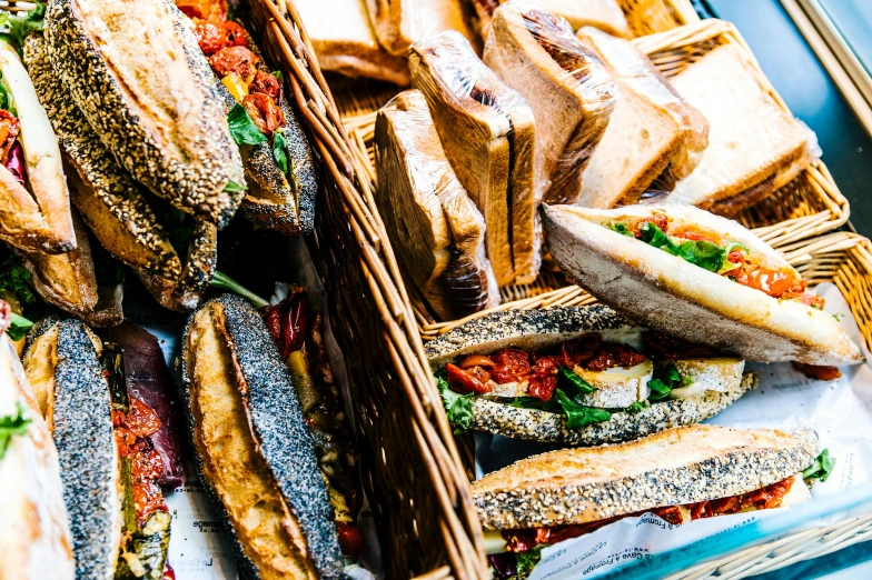 a tray full of sandwiches sitting on top of a table, by Joe Bowler, fish seafood markets, holding a baguette, thumbnail, vivid and vibrant