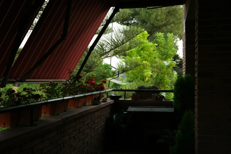 a person sitting at a table on a balcony, by Alessandro Allori, light and space, awnings, plants and trees, canopee, panoramic shot