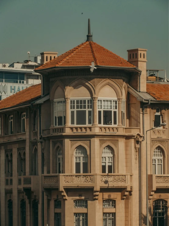 a large building with a clock on top of it, a colorized photo, pexels contest winner, tiled roofs, located in hajibektash complex, background image, wide windows