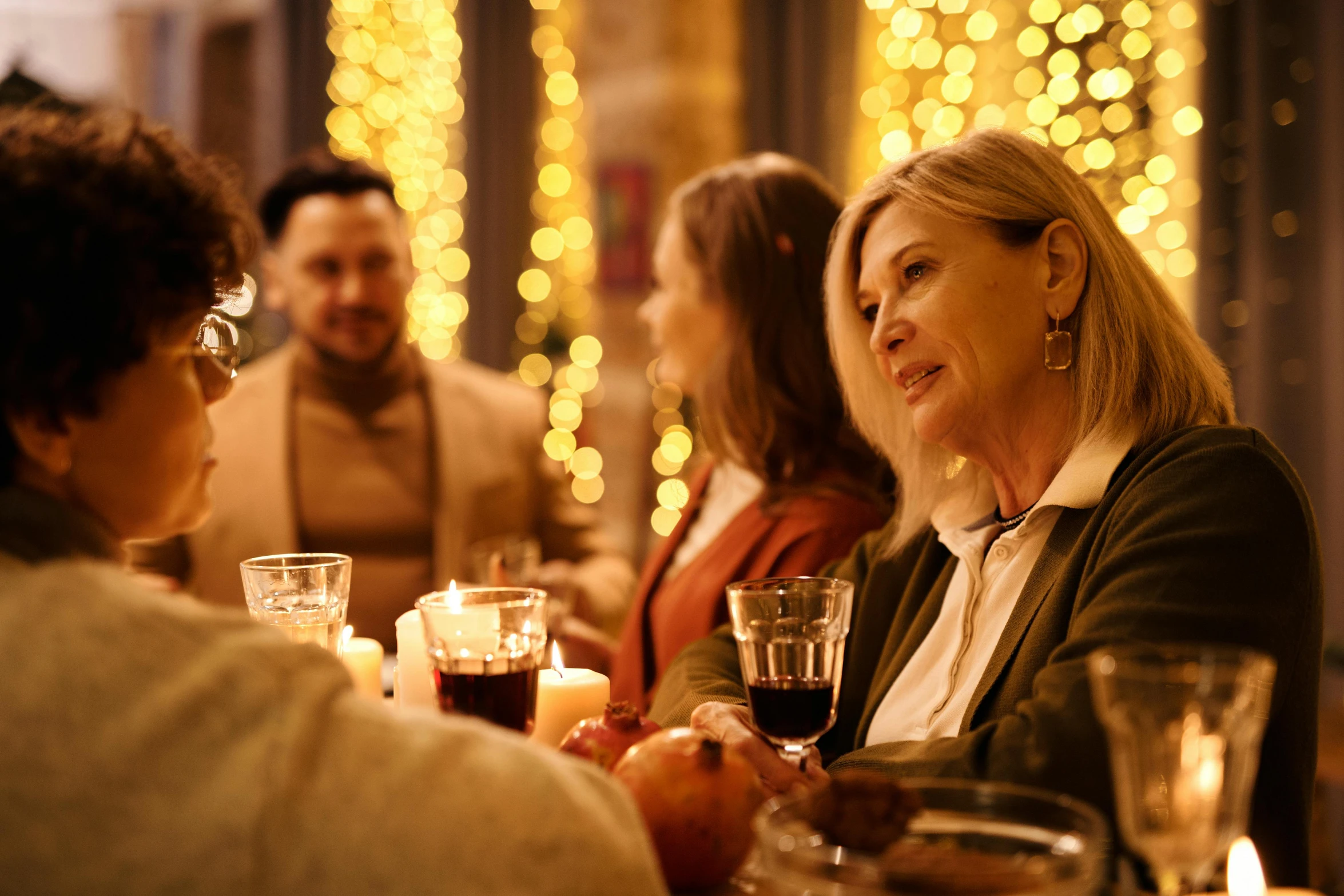 a group of people sitting around a dinner table, warm coloured, festive, profile image