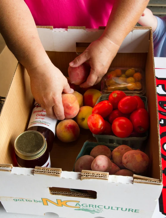 a close up of a box of fruit and vegetables, hands on counter, peaches, thumbnail, cream of the crop