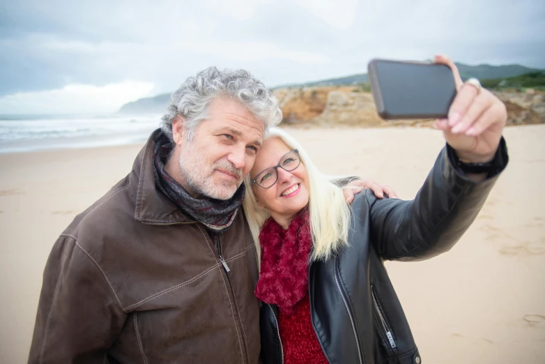 a man and woman taking a selfie on the beach, grey beard, avatar image, professional photograph, australian