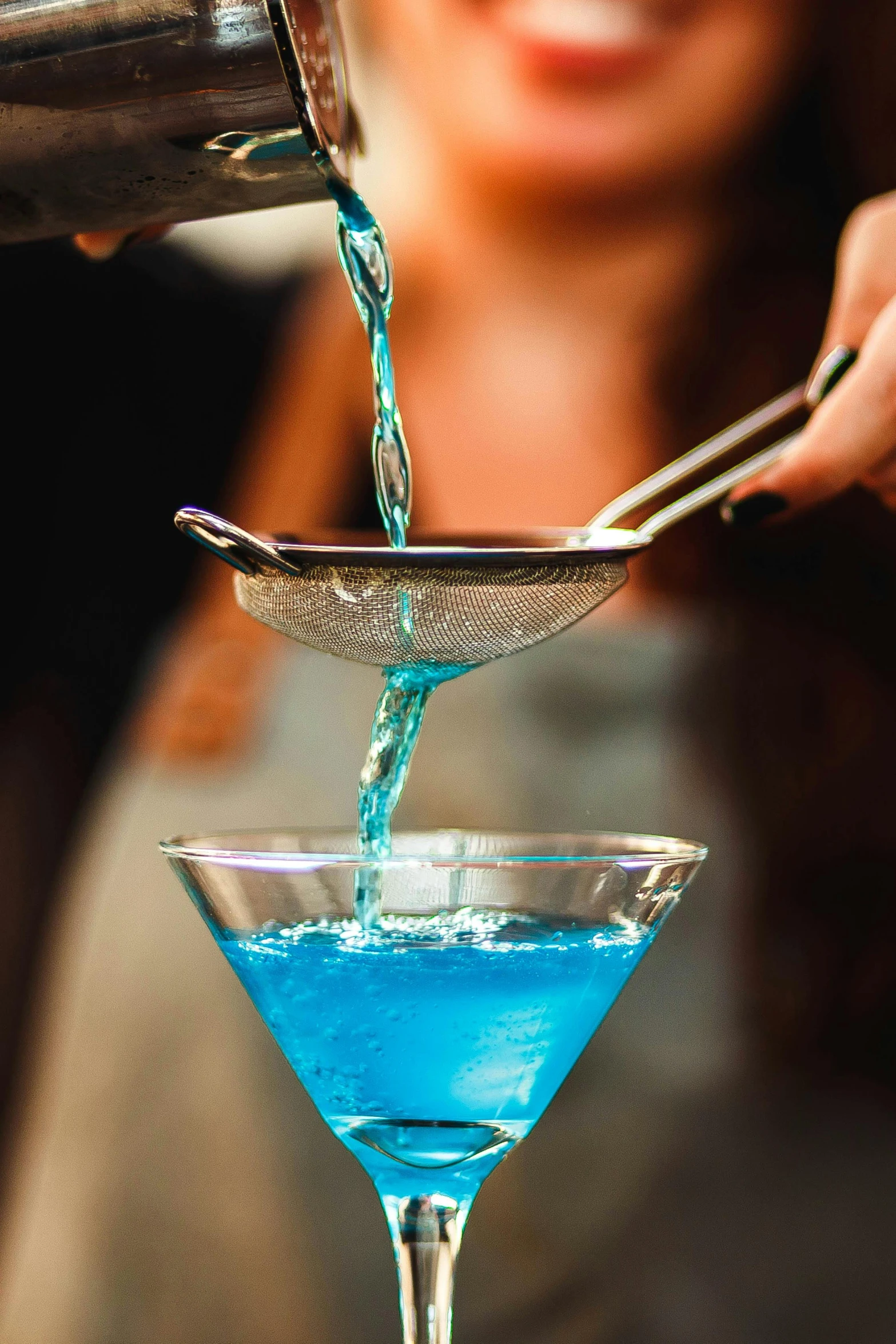 a woman pouring blue liquid into a martini glass, trending on reddit, highly upvoted, closeup - view, bartending, turquoise