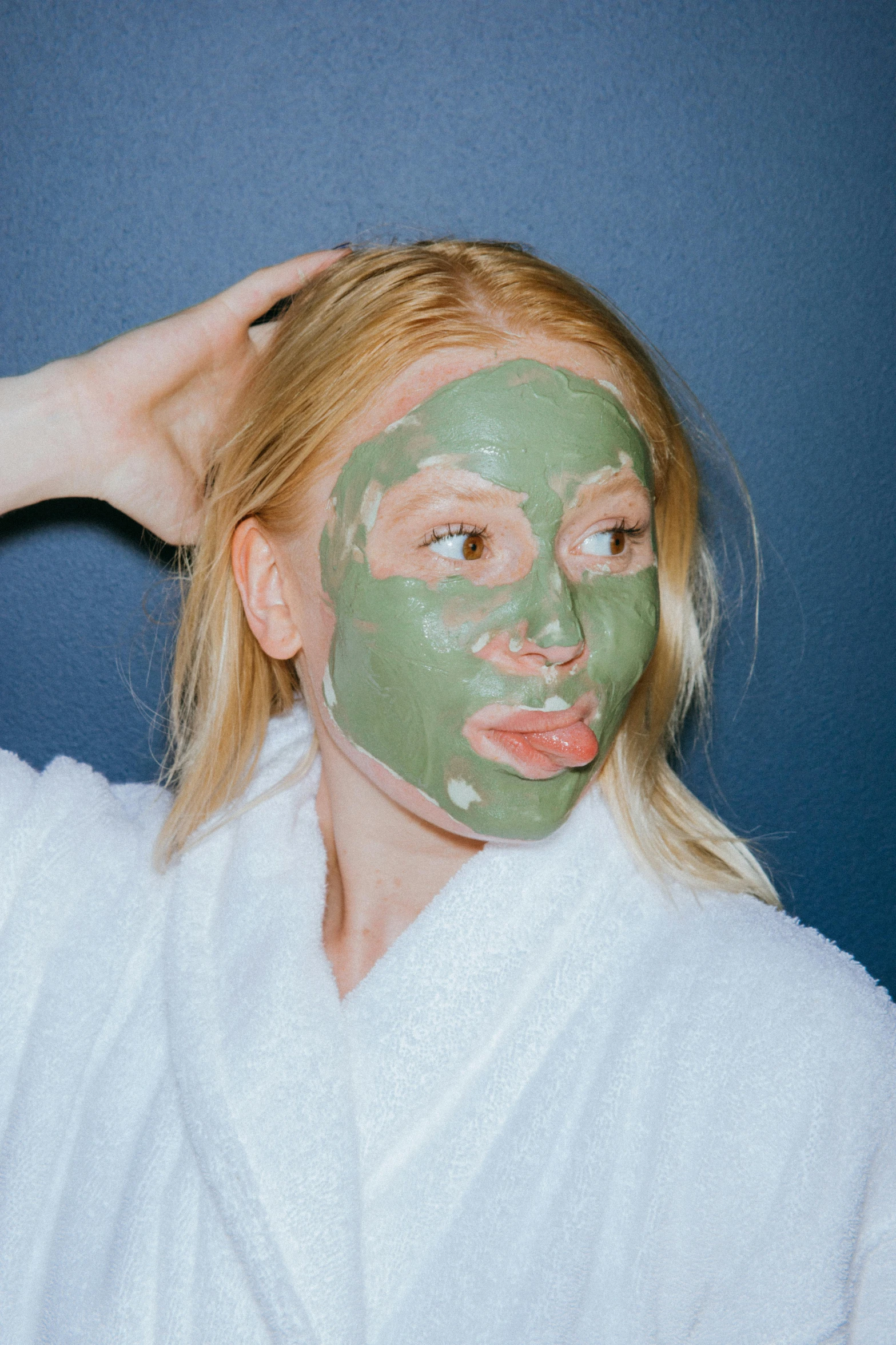 a woman putting a facial mask on her face, a colorized photo, trending on pexels, sage green, blond, covered in, green skinned