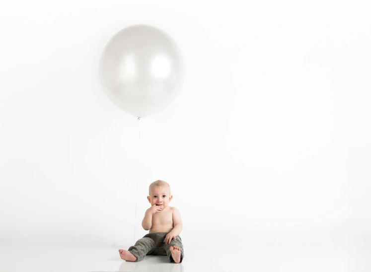 a baby sitting in front of a white balloon, shiny silver, full product shot, origin 100i, white space