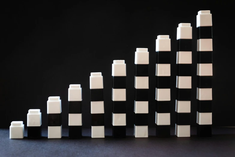 a group of black and white blocks sitting on top of a table, inspired by Frederick Hammersley, unsplash, towering, lego, bar charts, serge lutens