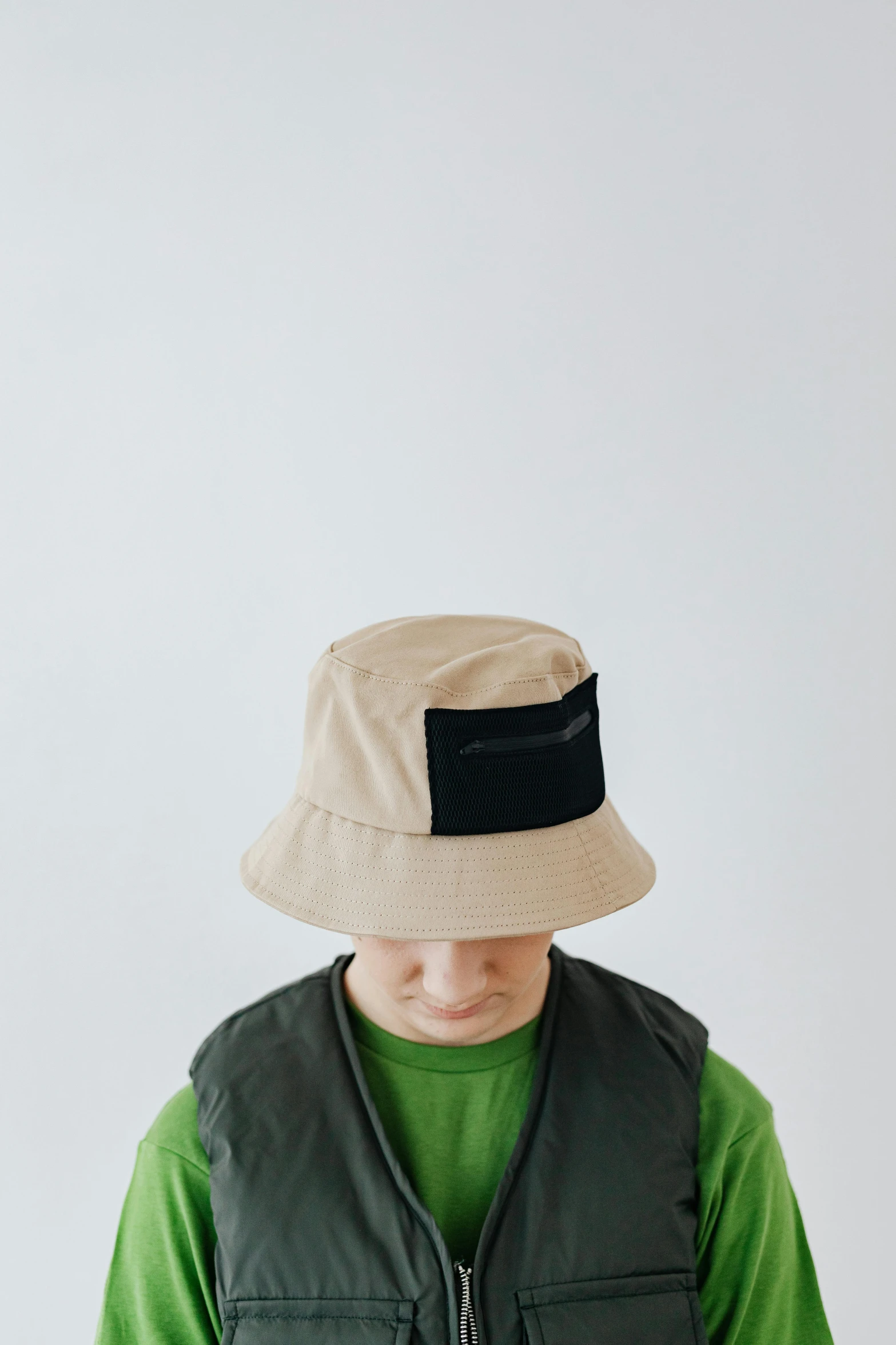 a man wearing a hat and green shirt, inspired by Joseph Beuys, unsplash, mingei, kids, beige, label, made of rubber