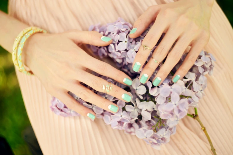 a woman holding a bouquet of purple flowers, unsplash, aestheticism, gradient pastel green, nail art, cyan and gold scheme, “diamonds