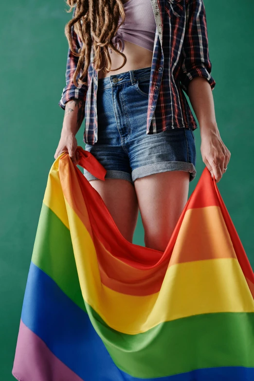 a woman with dreadlocks holding a rainbow flag, by Julia Pishtar, shutterstock, renaissance, wearing a shirt and a jean, miniskirt, plus-sized, greens)