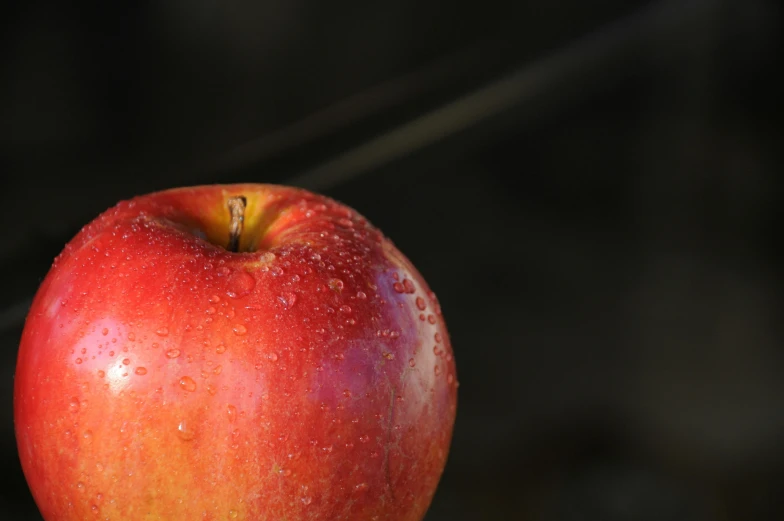 a red apple sitting on top of a wooden table, by Jan Rustem, unsplash, 15081959 21121991 01012000 4k, closeup at the food, in front of a black background, outdoor photo