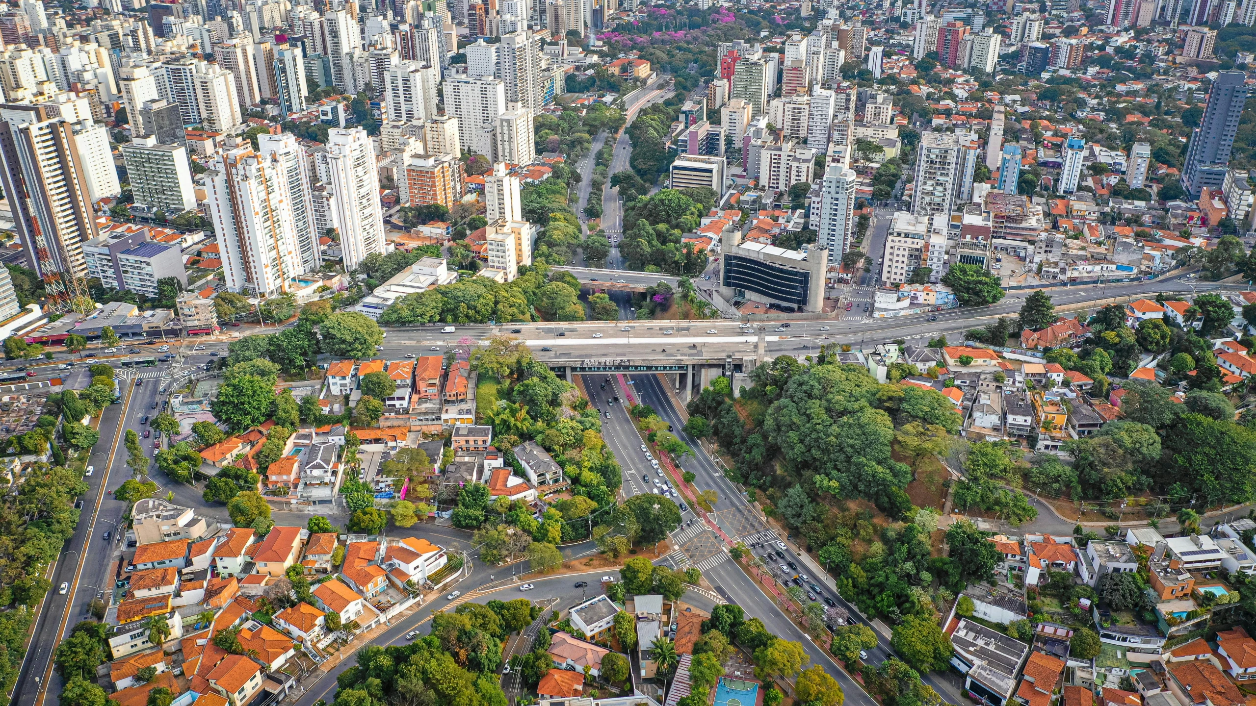 an aerial view of a city with lots of buildings, by Felipe Seade, tall bridge with city on top, bolsonaro, houses and roads, thumbnail