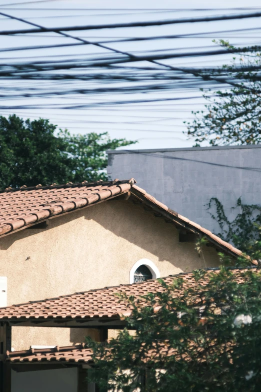 a red stop sign sitting on the side of a road, an album cover, inspired by Elsa Bleda, trending on unsplash, renaissance, tiled roofs, colombo sri lanka cityscape, village house, tangled overhead wires