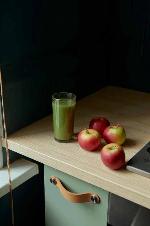 a laptop computer sitting on top of a wooden desk, a still life, by Doug Ohlson, hyperrealism, juice, in a kitchen, muted green, detail shot