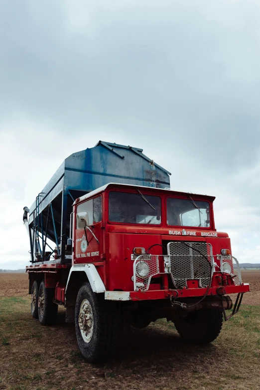 a red truck is parked in a field, willim blake, silo, large blue engines, documentary photo
