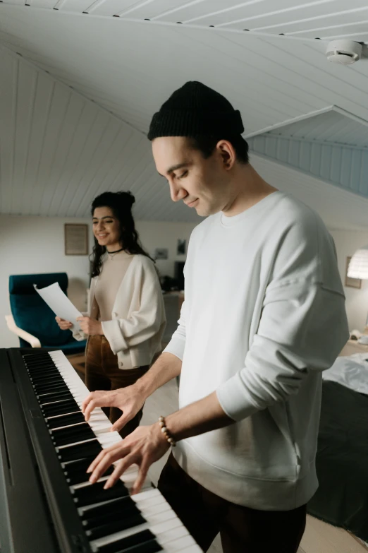 a man standing next to a woman playing a piano, no cropping, millennial vibes, thumbnail, single subject