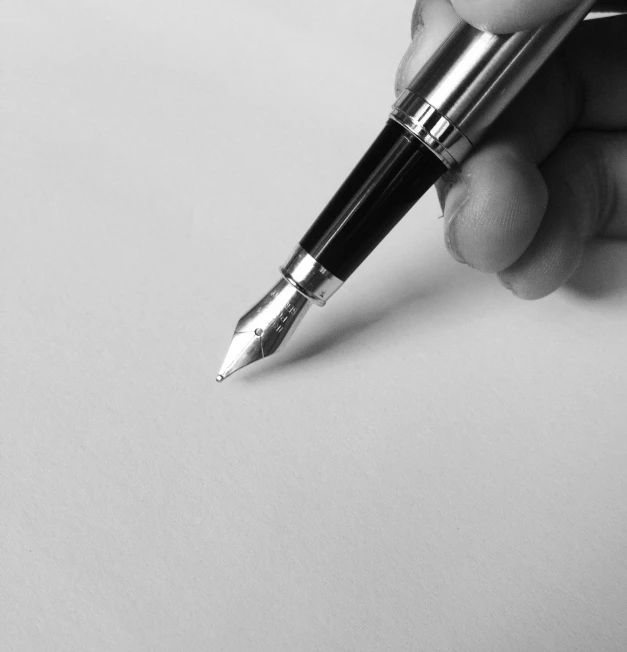 a person holding a pen in their hand, by Mathias Kollros, pixabay, black on white paper, fountain pen, high details photo