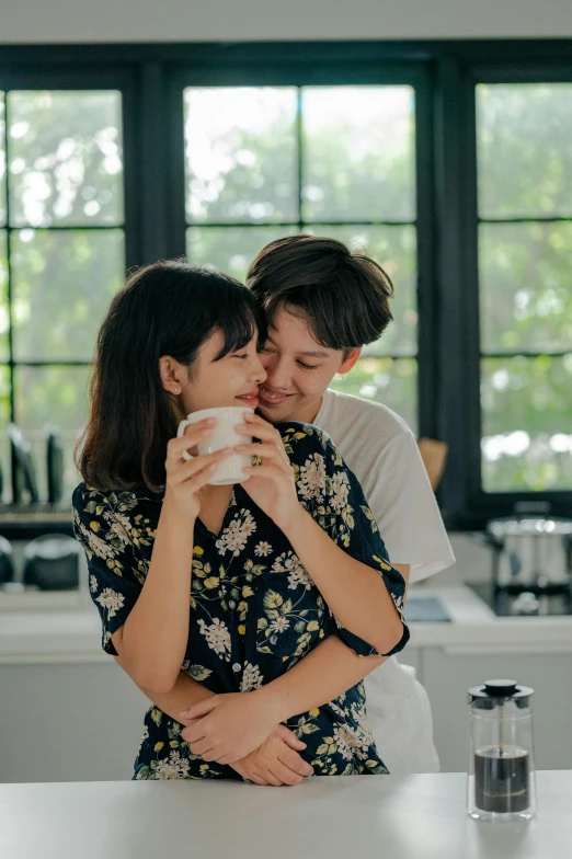 a man and a woman hugging in a kitchen, trending on pexels, with a white mug, lesbian kiss, taiwan, profile image