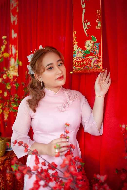a woman standing in front of a red curtain, inspired by Pu Hua, pexels contest winner, ao dai, belle delphine, square, deity)