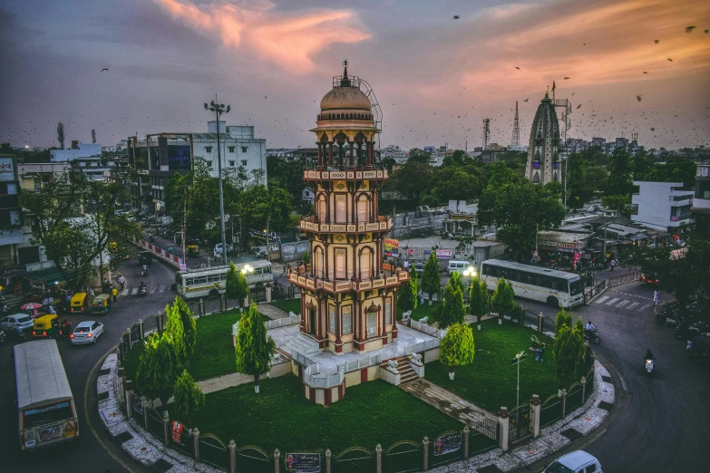 a clock tower sitting on top of a lush green field, pexels contest winner, indore, pink marble building, aerial view of a city, temple fair