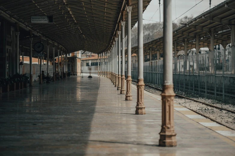 a train station with a train on the tracks, by Alejandro Obregón, unsplash contest winner, hyperrealism, arches adorned pillars, empty stools, transparent background, empty street