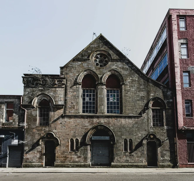 a large brick building sitting on the side of a road, inspired by Thomas Struth, pexels contest winner, renaissance, glasgow, cyberpunk church, exterior view, aged and weathered