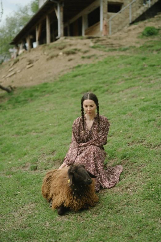 a woman sitting on the ground next to a sheep, inspired by Oleg Oprisco, unsplash, renaissance, brown clothes, bhutan, still from a live action movie, a dog