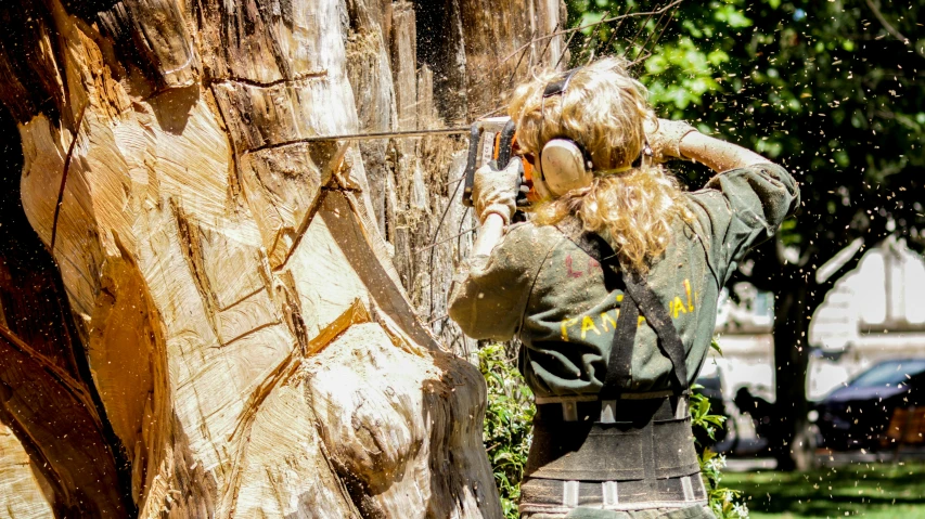 a woman cutting a tree with a chainsaw, by Lee Loughridge, pexels contest winner, auto-destructive art, side profile artwork, wooden bark armor, panoramic shot, 1990's photo