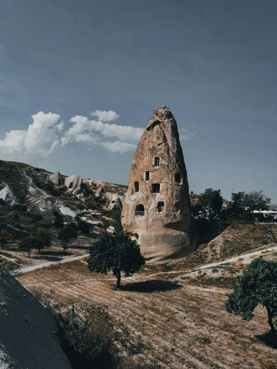 a man riding a skateboard on top of a dirt road, a detailed matte painting, pexels contest winner, art nouveau, old ruins tower, turkey, panoramic view of girl, empty bathhouse hidden in a cave