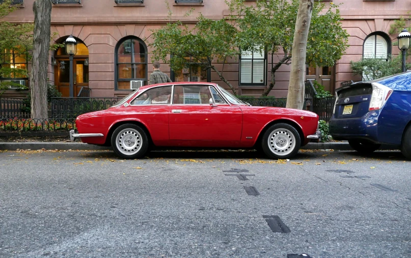 a red car parked on the side of the road, pexels contest winner, renaissance, in 1960s new york, alfa romeo giulia, computer, taken in the late 2000s