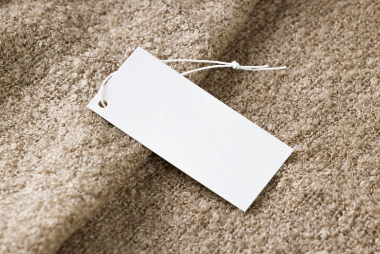 a white price tag sitting on top of a pile of carpet, listing image, rectangle, hires, design only