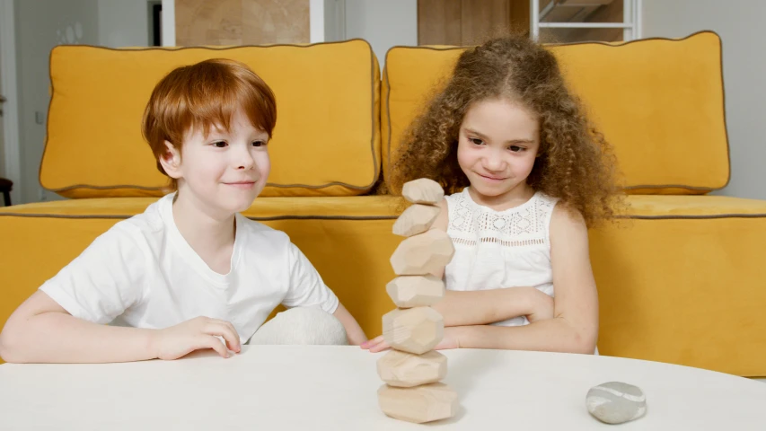 a couple of kids that are sitting at a table, inspired by Sarah Lucas, pexels contest winner, hexagonal stones, twisted giant tower, product introduction photo, promotional image