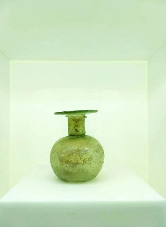 a green vase sitting on top of a white shelf, by artist, arte povera, exhibited at the british museum, glass antikythera, bottom - view, david kassan