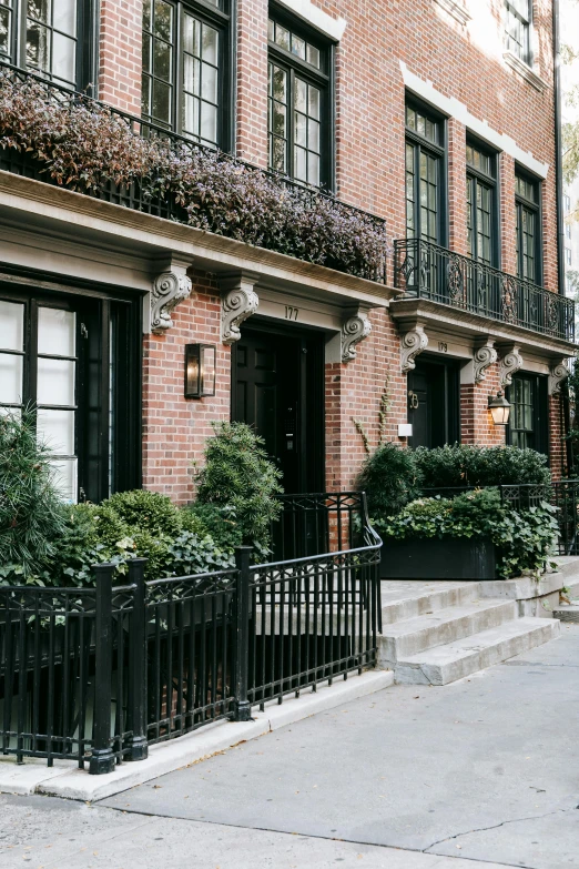 a red fire hydrant sitting on the side of a street, by Nina Hamnett, trending on unsplash, art nouveau, plants on balconies, of mad men on madison avenue, buildings covered in black tar, french village exterior