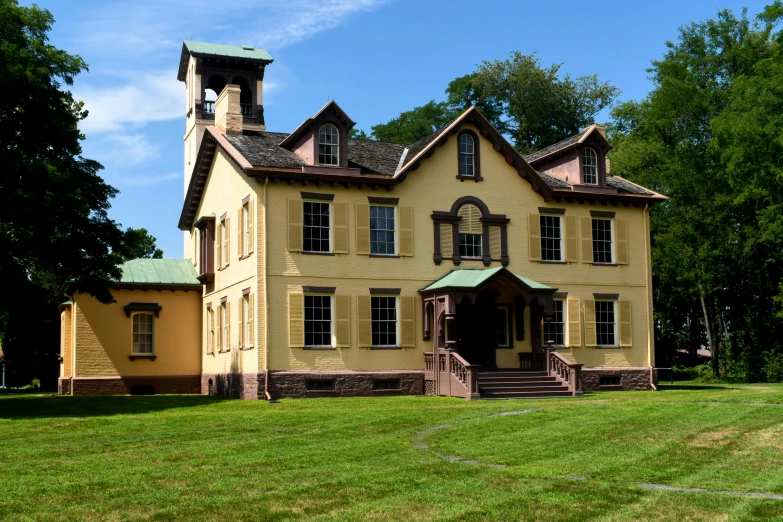 a large yellow house sitting on top of a lush green field, inspired by Alfred Thompson Bricher, hudson river school, front and side elevation, barracks, watch photo, slate