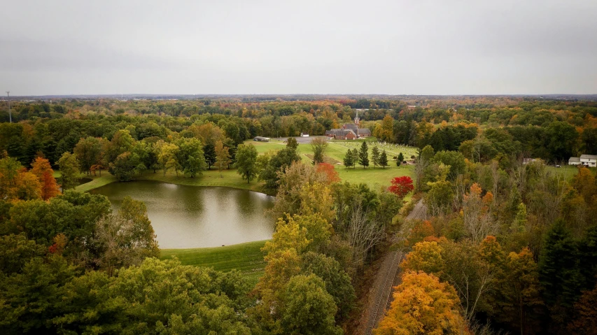 an aerial view of a golf course surrounded by trees, vermilion and red lake, red barn in distance, william penn state forest, instagram photo