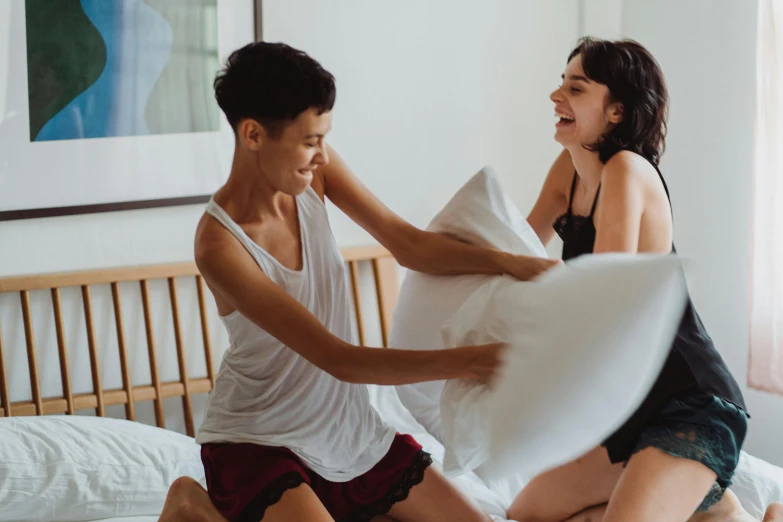 a couple of people that are on a bed, pexels contest winner, happening, earing a shirt laughing, throw pillows, lesbian, ruan jia and brom