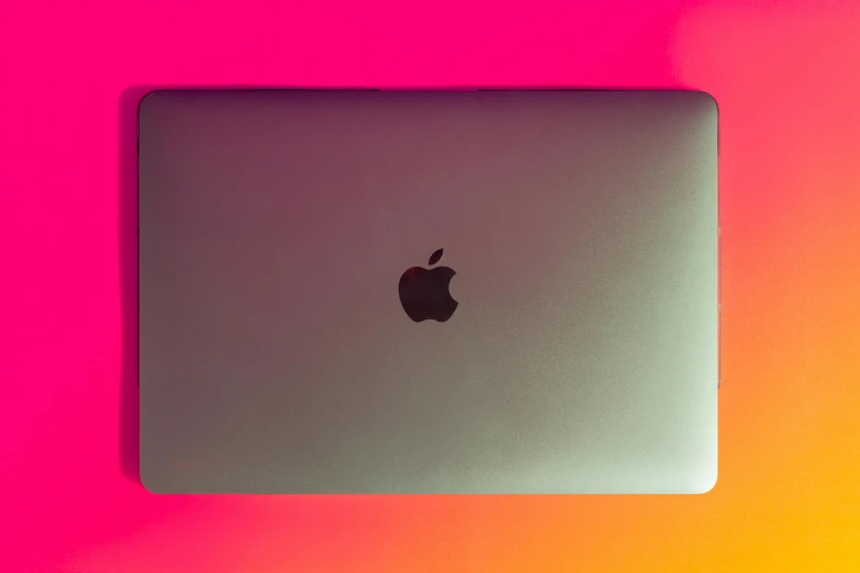 a laptop computer sitting on top of a table, by Carey Morris, pexels, computer art, gradient pink, apple orange, lit from above, red apple