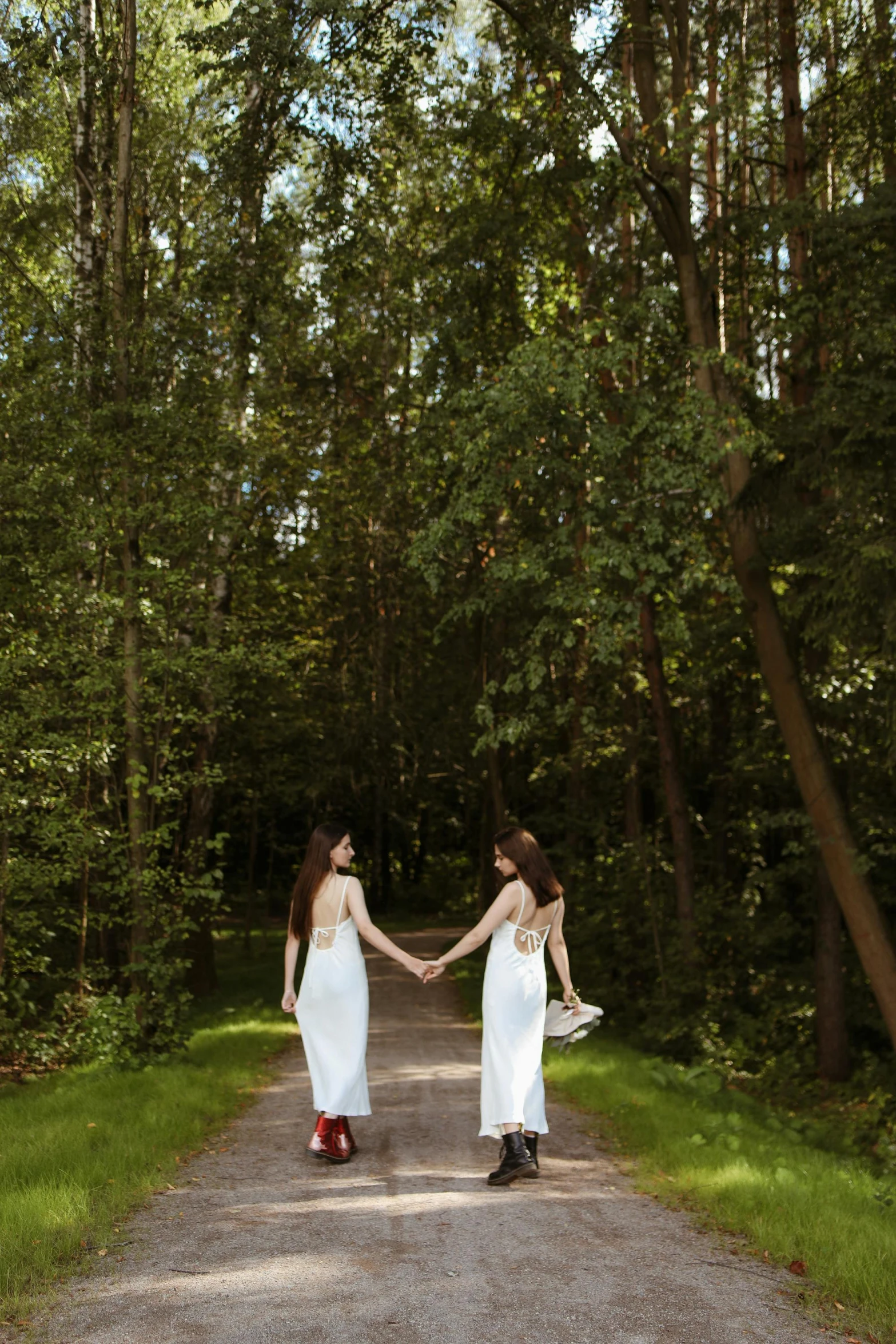 two women walking down a dirt road holding hands, an album cover, by Julia Pishtar, renaissance, majestic forest grove, in a long white dress, minn, sha xi