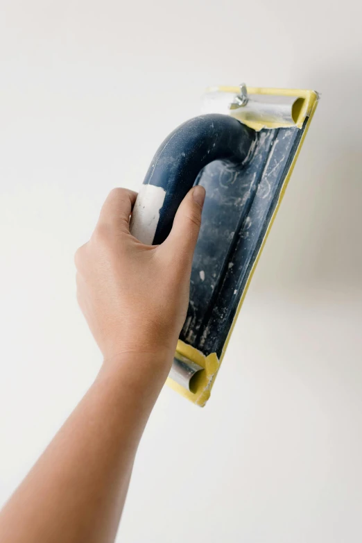 a person using a paint roller to paint a wall, by Ben Zoeller, a telephone receiver in hand, high-quality photo, demur, resin