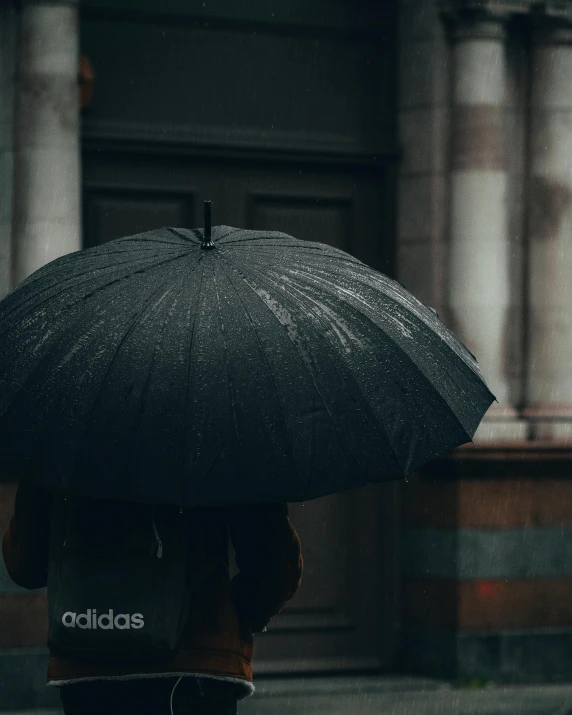 a person walking in the rain with an umbrella, addidas, black on black, promo image, lgbtq